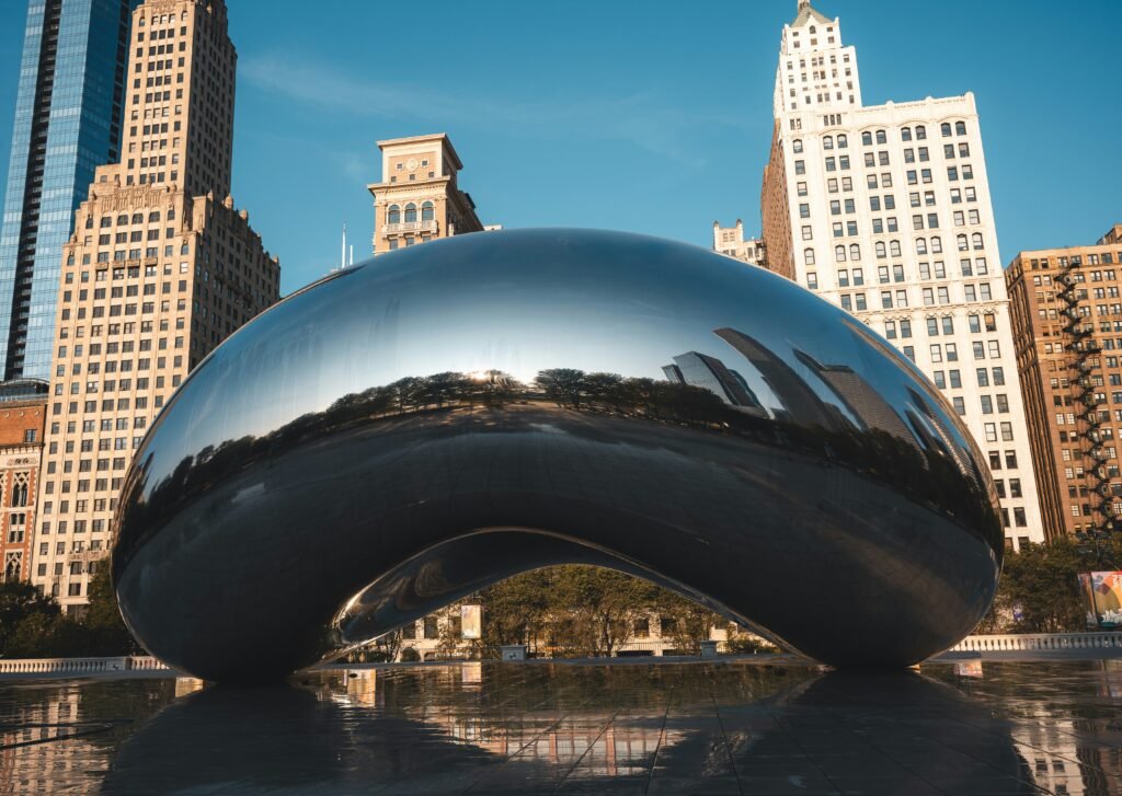 Cloud Gate sculpture reflecting Chicago skyline on a clear morning