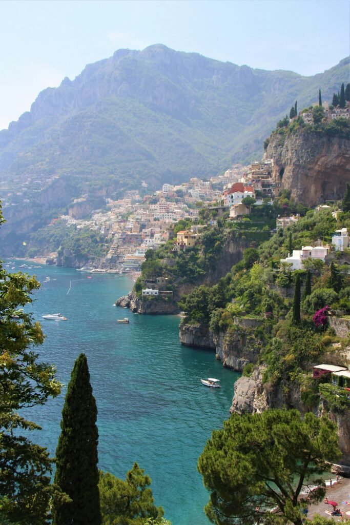 Positano from above showing the colorful buildings cascading down the cliffside to the beach and the blue sea