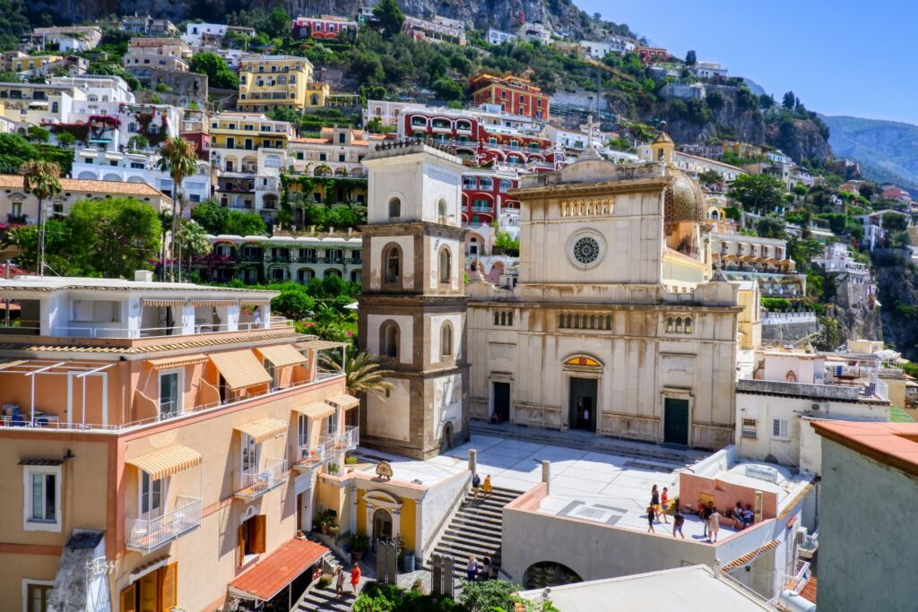 Santa Maria Assunta Church in Positano surrounded by colorful hillside buildings on Italy’s Amalfi Coast.
