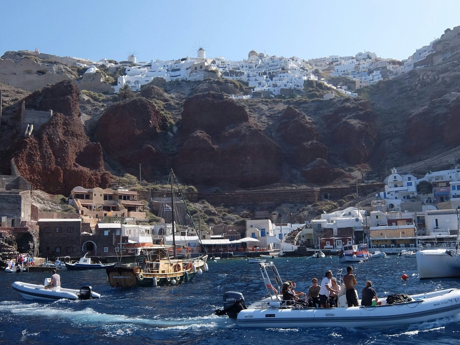 Santorini caldera cliffs and blue Aegean water seen from a boat
