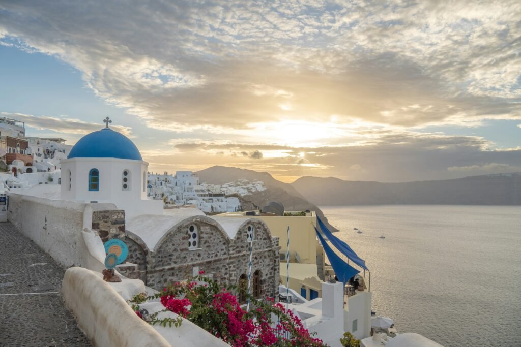 Oia village in Santorini at sunrise with whitewashed houses above the caldera