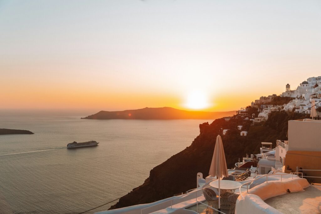 Santorini caldera at sunset with white cliffside buildings and the Aegean Sea