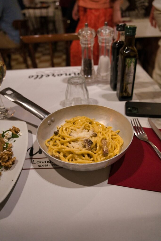 A pan of classic Roman pasta served at a restaurant table in Rome