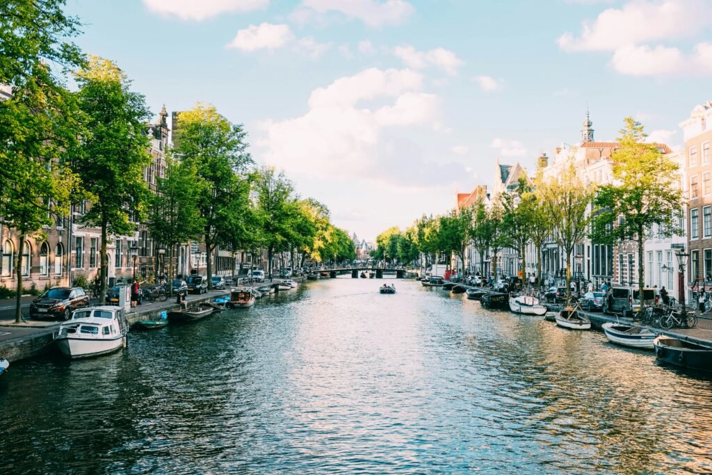 Amsterdam canal lined with boats and historic houses in September light