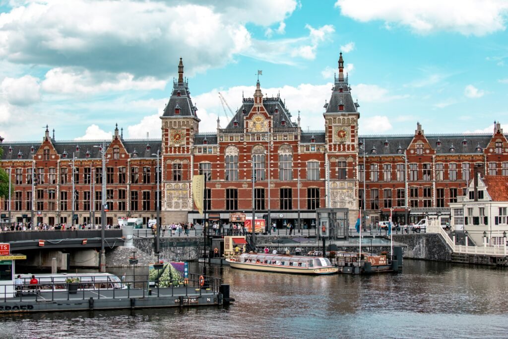 Amsterdam Centraal Station with canal boats on the waterfront