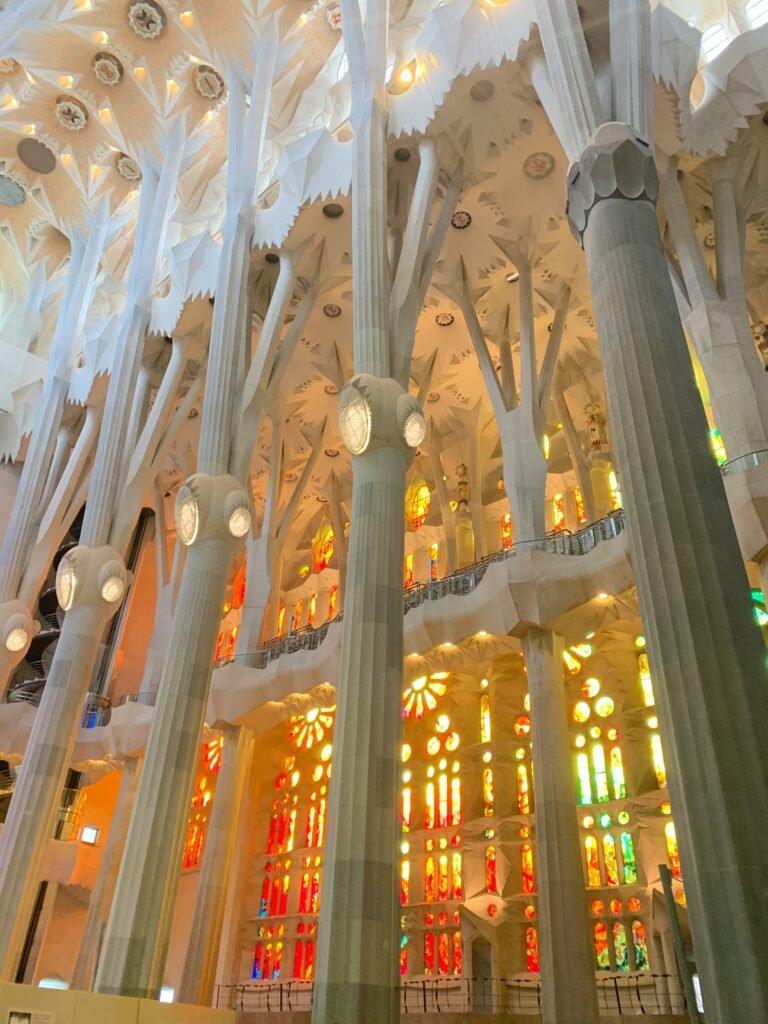 Interior of the Sagrada Família in Barcelona with branching columns and colorful stained glass light