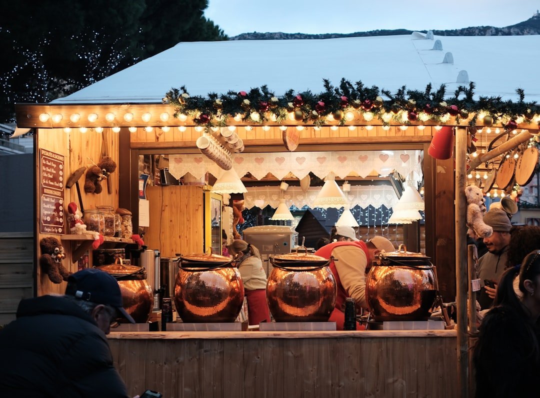 A cozy Christmas market stall with copper mulled wine kettles, garland, and string lights, matching Leavenworth's Front Street Park vendor stalls