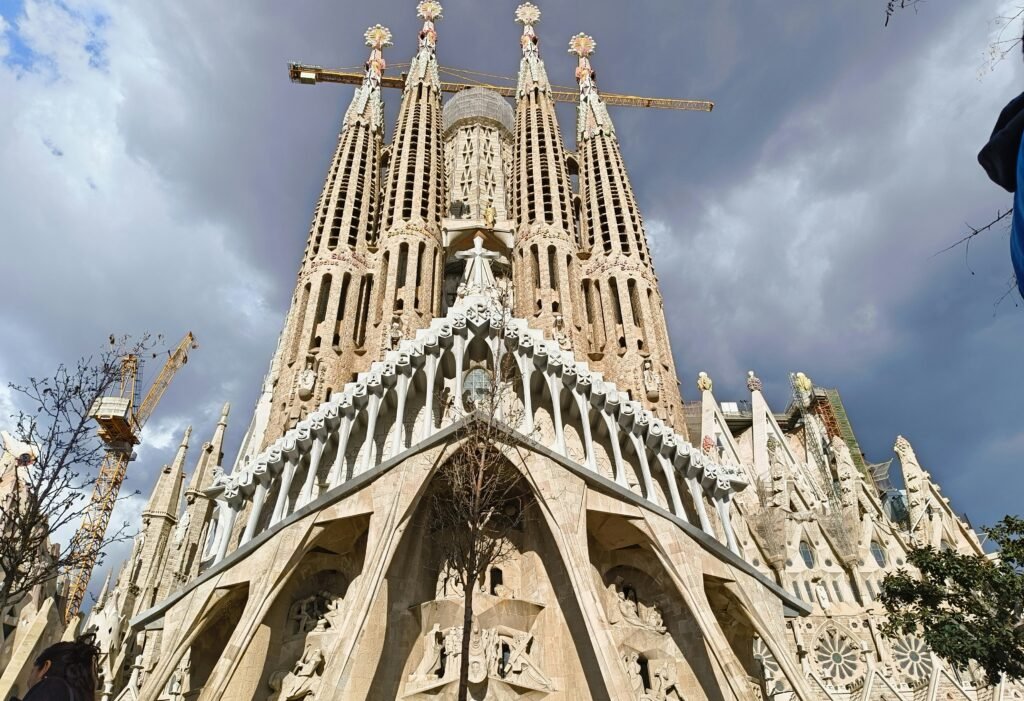 Sagrada Familia facade in Barcelona under a cloudy sky